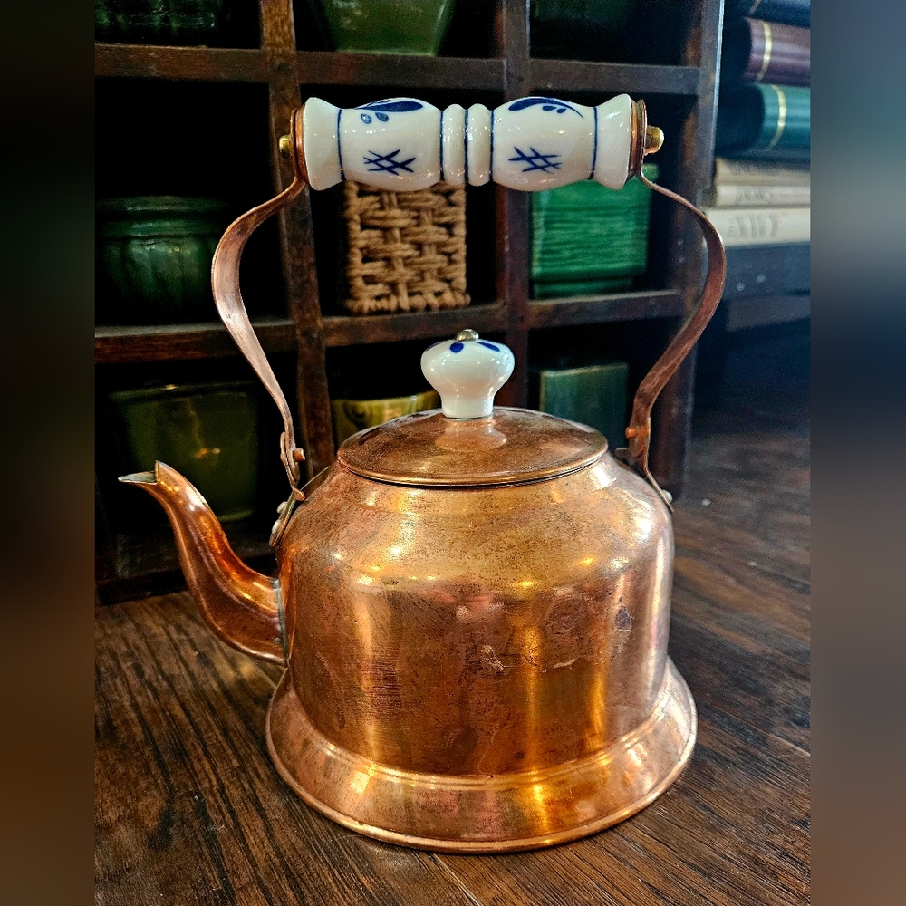 Vintage copper teapot tea kettle with blue and white ceramic handles.